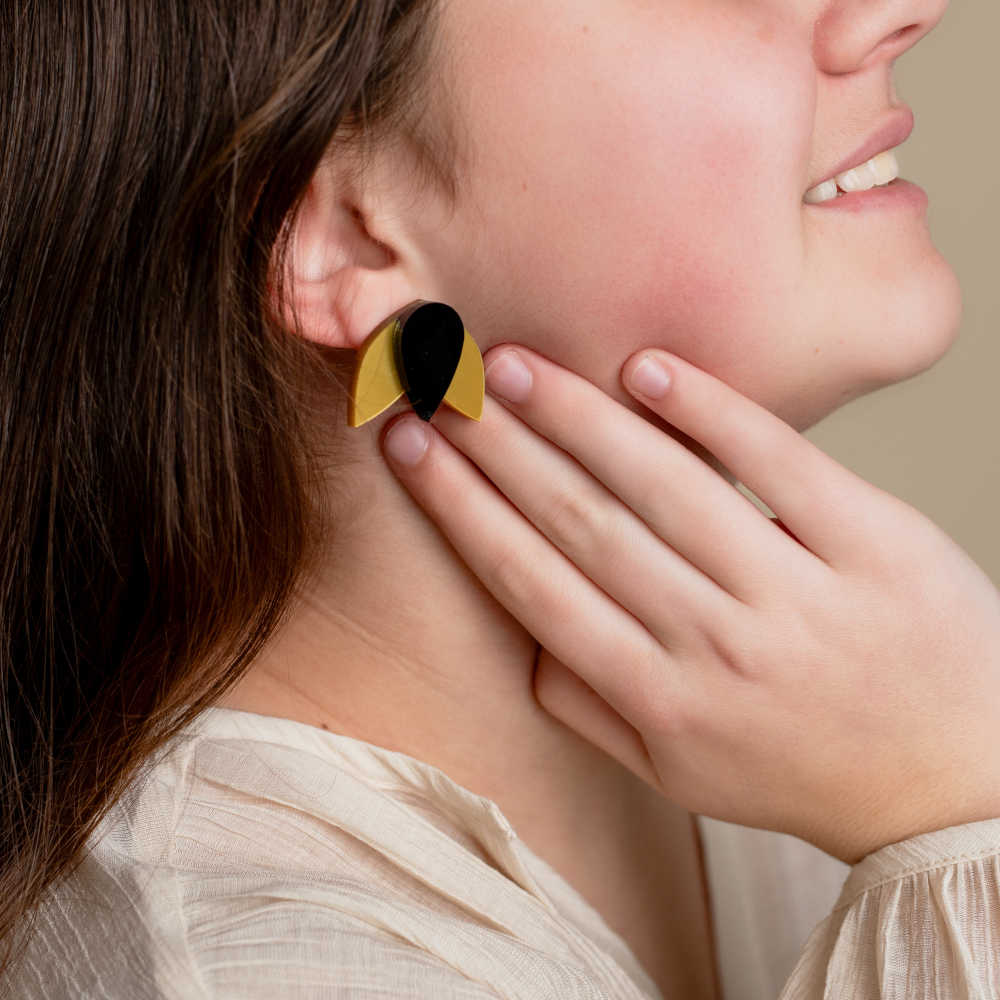 Modelo con pendientes Tulipán en color dorado y negro